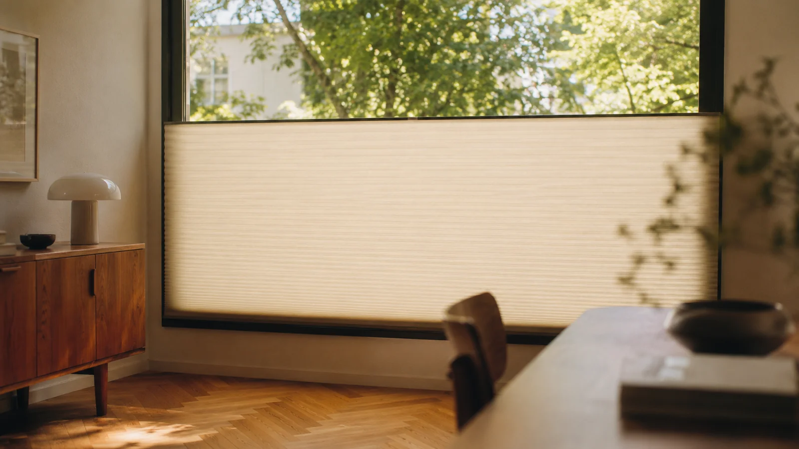 Wabenplissee an einem Süd-Fenster im Hochsommer, Stoff geschlossen, Sonnenlicht diffundiert sanft in den kühlen Raum